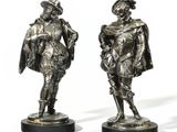 three bronze figurines of men dressed in costumes and hats