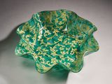 a green glass bowl with gold designs on it