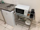 a microwave and a small refrigerator in a small kitchen