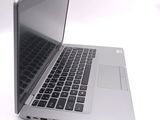 a silver laptop with a black keyboard on a white surface