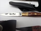 a knife that is laying on a table next to other knives