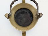 a small metal object hanging on a white wall