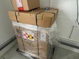 une pile de cartons posée sur un chariot dans une pièce