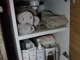 a cabinet with a lot of towels and other items in it