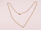 un collier à chaîne en or orné d'une seule perle sur fond blanc