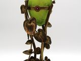 un vase vert orné d'un oiseau, posé sur un socle