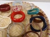 many different colored bracelets on a tray on a table