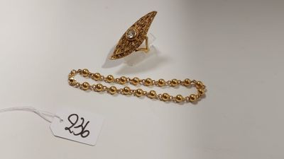 un gros plan d'un collier et d'une bague posés sur une surface blanche