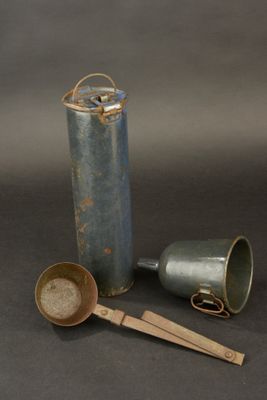 a small metal container with a spoon and a measuring spoon