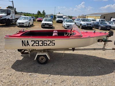 un bateau posé sur une remorque dans un parking