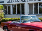 a red convertible car parked in front of a building