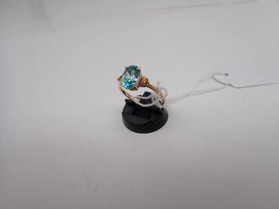 un gros plan d'une bague sertie d'une topaze bleue sur un support noir