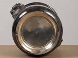 a silver plate with a lion head on it on a table