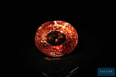 gros plan d'un diamant orange sur une surface noire