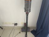 une photo d'une pièce où l'on voit un aspirateur et une carte accrochée au mur