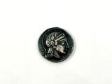 an image of a silver coin with a face on it