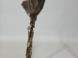 bronze sculpture of a woman holding a fan on a wooden base
