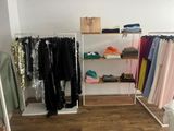 a rack of clothes in a clothing store with clothes hanging on it