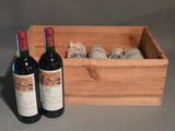 deux bouteilles de vin dans un coffret en bois à côté d'une bouteille de vin