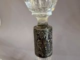 a glass bottle with a metal stopper on top of it