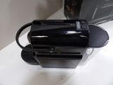 a black toaster sitting on a counter next to a black bag