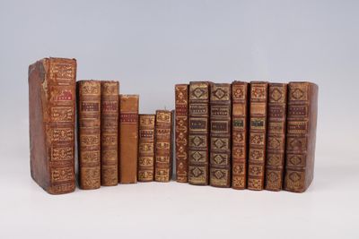 plusieurs vieux livres sont alignés sur une surface blanche