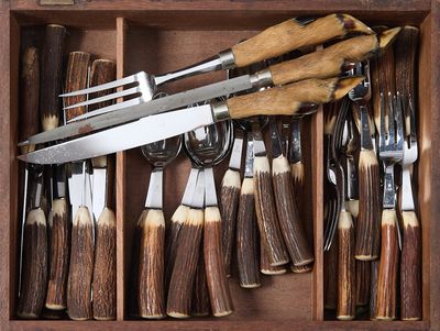 de nombreux types de couteaux et de fourchettes dans une boîte en bois