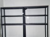 two shelves in the corner of a room with a bench