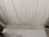 a bed with a white sheet covering it in the middle of a room