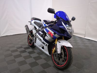 une moto bleue et blanche garée sur un sol à carreaux noirs et blancs