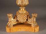 a gold vase on a marble base with lions around it