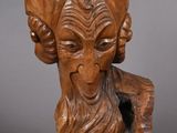 a close up of a wooden sculpture of a ram with long hair