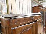 a wooden cabinet with a marble top in the middle of a room