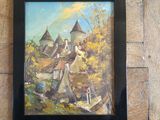 framed oil painting of a village scene in a black frame on a wooden wall