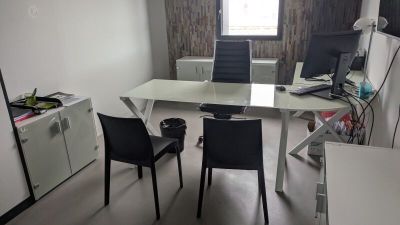 un bureau avec deux chaises et un ordinateur dessus