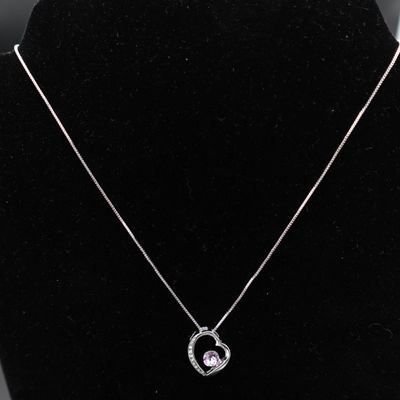 un collier en argent avec un pendentif en forme de cœur sur un mannequin noir