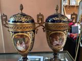 two vases are sitting on a glass table in front of a mirror
