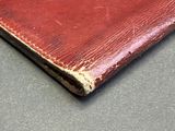 an old red leather wallet sitting on top of a table