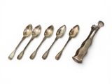 six spoons and a spoon rest in a row on a white surface