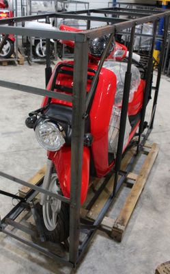 un scooter rouge garé à l'intérieur d'une cage métallique