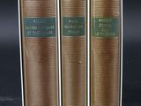 three books sitting on top of each other on a black surface