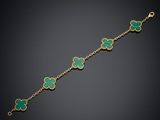 un bracelet en or 18 carats orné de breloques en forme de trèfle en émail vert