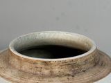a white vase with a brown rim sitting on a table