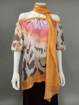 a mannequin mannequin wearing an orange scarf and black dress