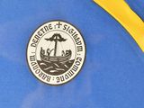 a picture of a blue and yellow backpack with a sticker on it