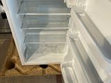 a white refrigerator with its door open in a kitchen
