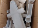 a cardboard box full of white plastic pipes and fittings
