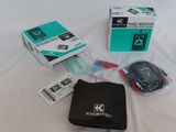 a box with a remote control and other items on a bed