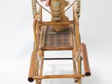 a small wooden rocking chair with a teddy bear on it
