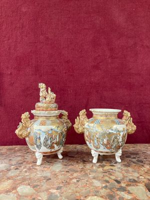 two vases on a table with a red wall in the background